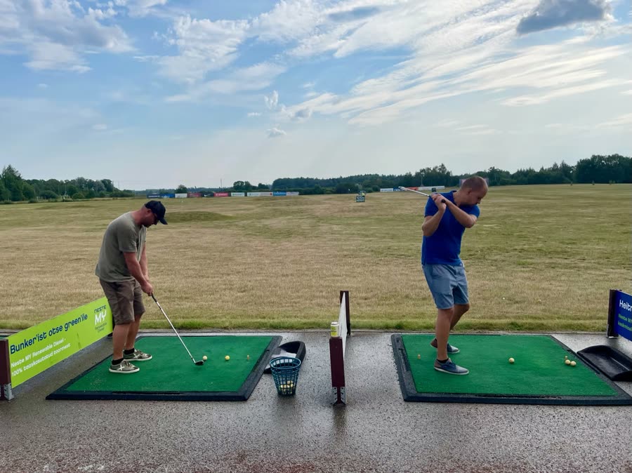 Two of the team at a driving range